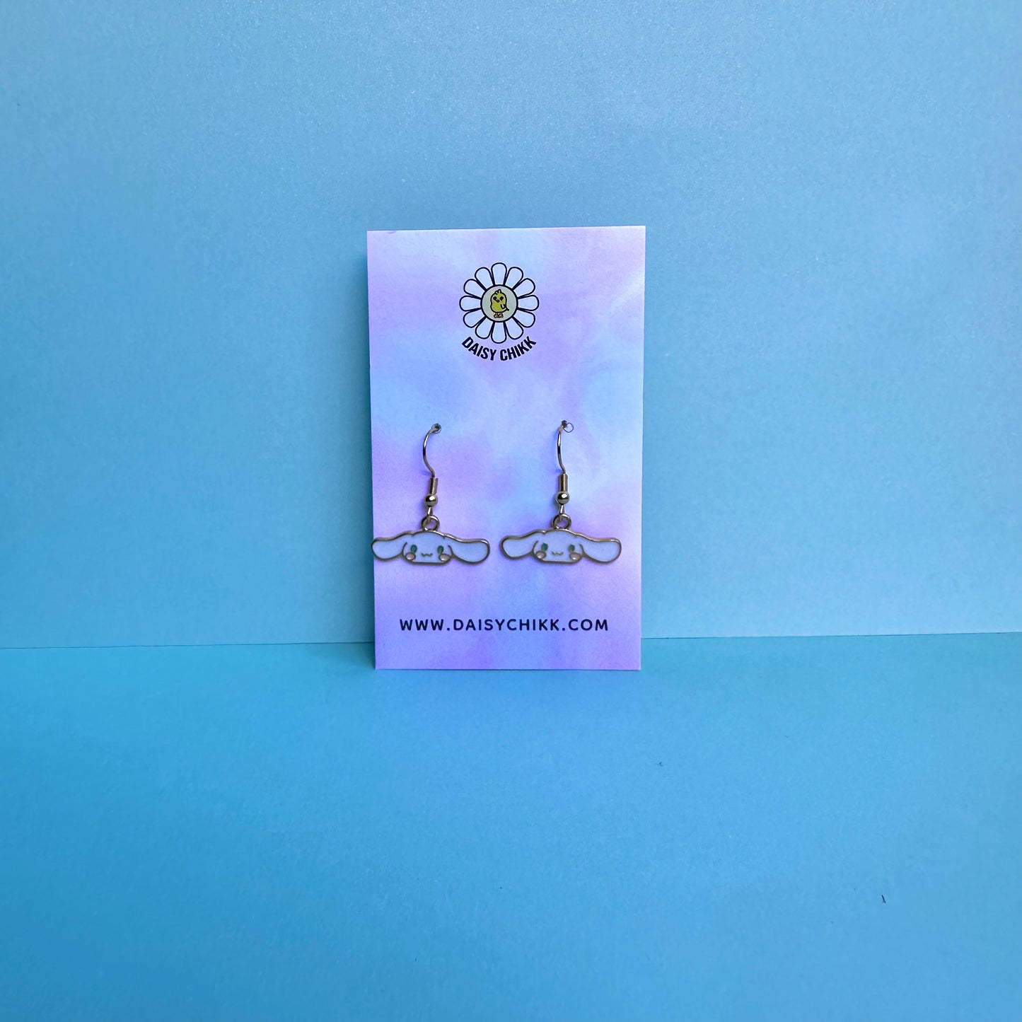 Cinnamoroll earrings on Daisy Chikk pastel earring card with purple and blue ombré background – handmade Sanrio-style kawaii jewellery