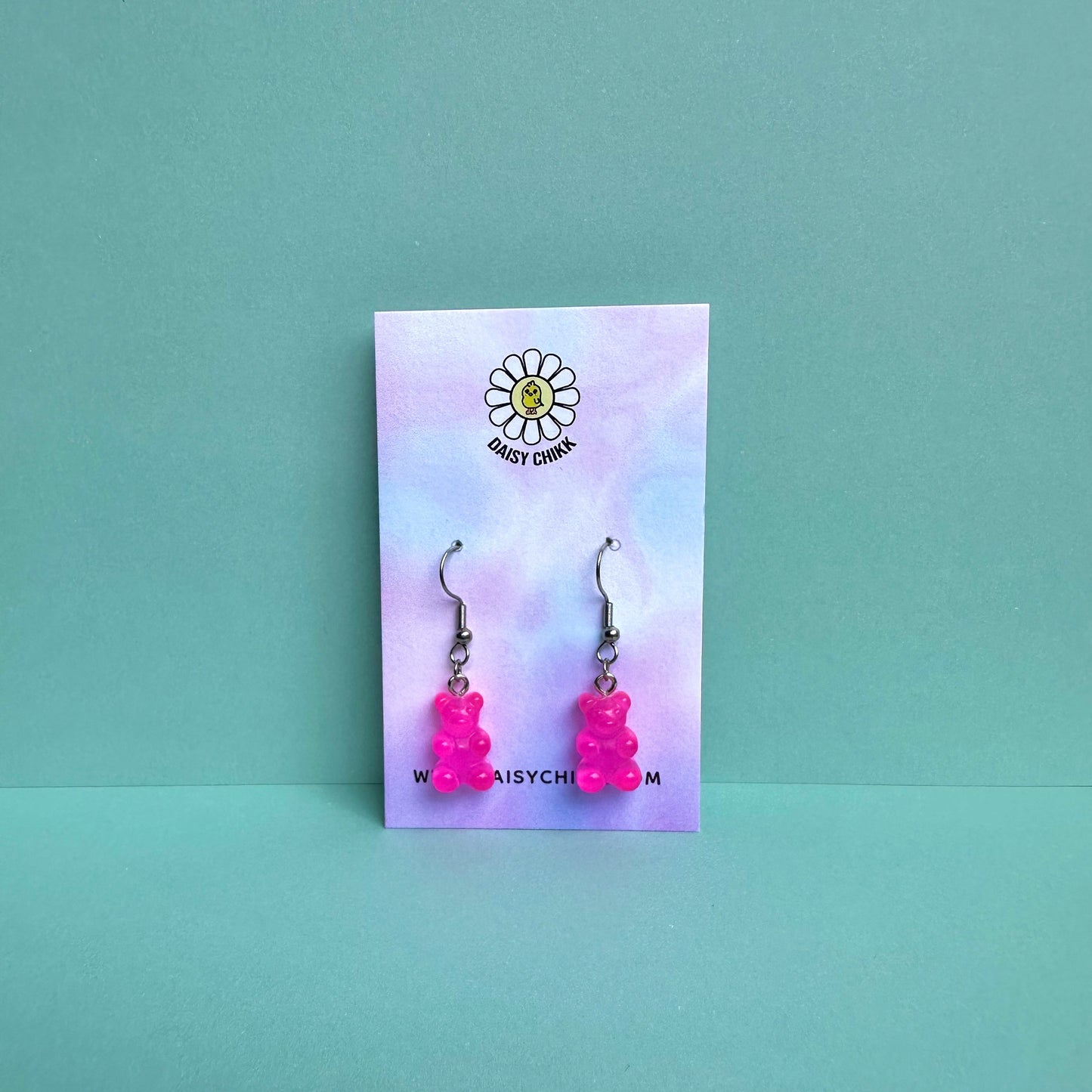 Hot pink gummy bear earrings on silver hooks displayed on a pastel Daisy Chikk backing card – handmade kawaii resin earrings