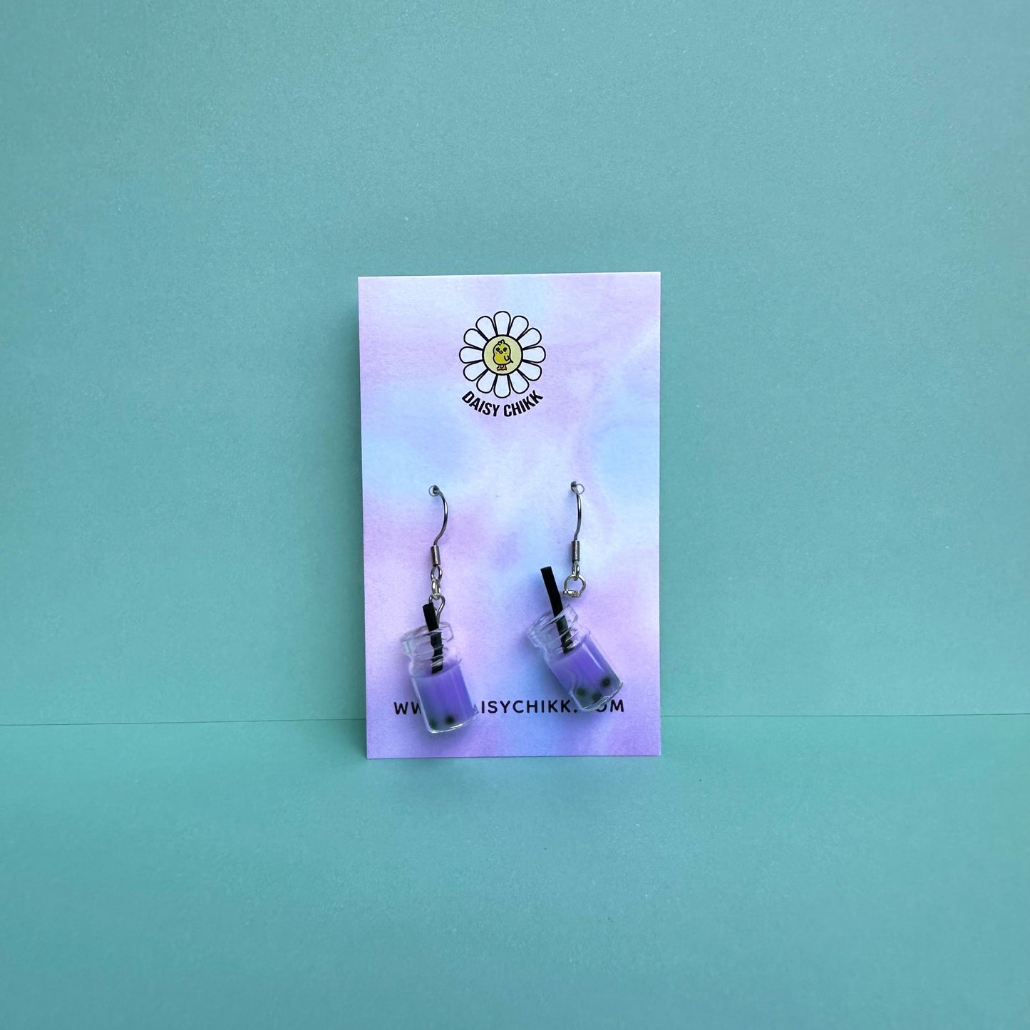 Purple boba tea earrings with silver hooks displayed on a pastel Daisy Chikk backing card – handmade kawaii bubble tea jewellery