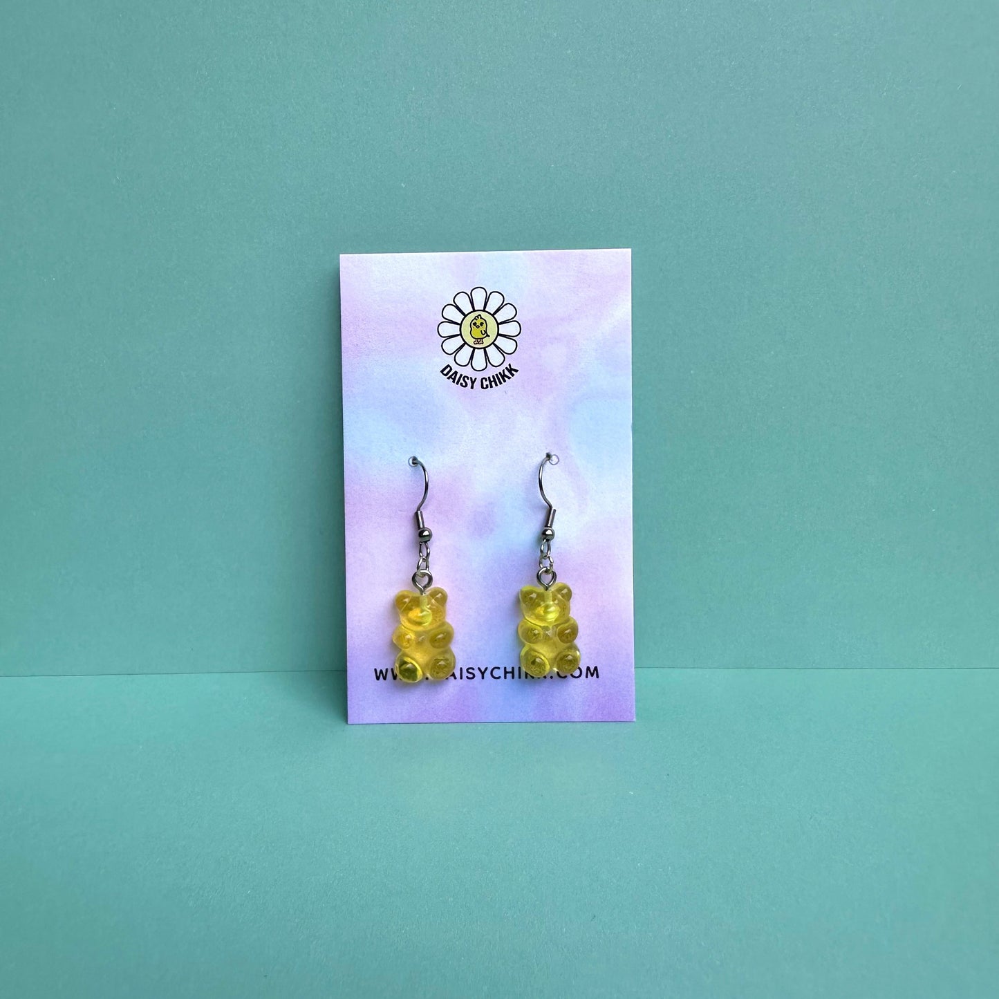 yellow gummy bear earrings on silver hooks displayed on a pastel Daisy Chikk backing card – handmade kawaii resin earrings