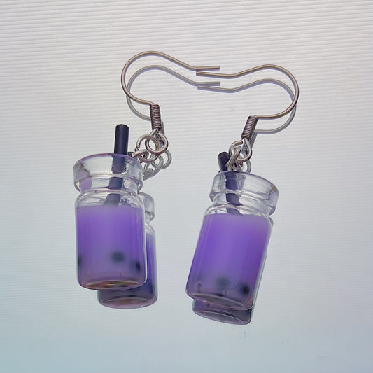 Close-up of handmade purple boba tea earrings with black straws and silver hooks – kawaii resin bubble tea jewellery