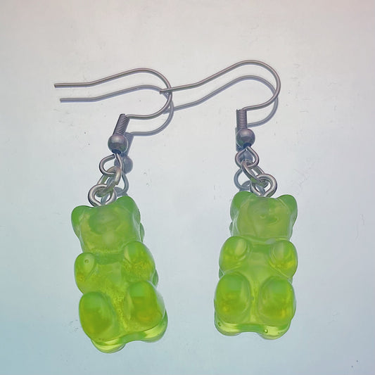 Close-up of translucent green gummy bear earrings with silver hooks on a pastel background – kawaii Y2K handmade jewellery