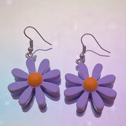 Close-up of purple daisy earrings with white centre and silver hooks on iridescent rainbow background – pastel soft girl Y2K jewellery aesthetic