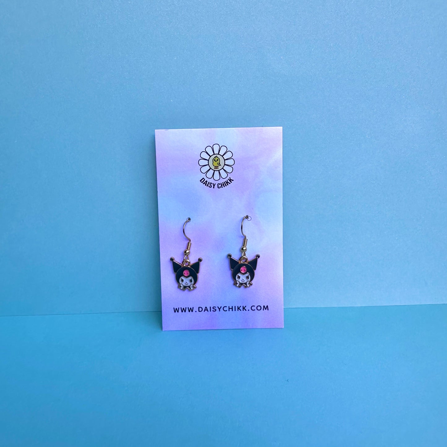 Kuromi earrings on Daisy Chikk pastel earring card with purple and blue ombré background – handmade Sanrio-style kawaii jewellery