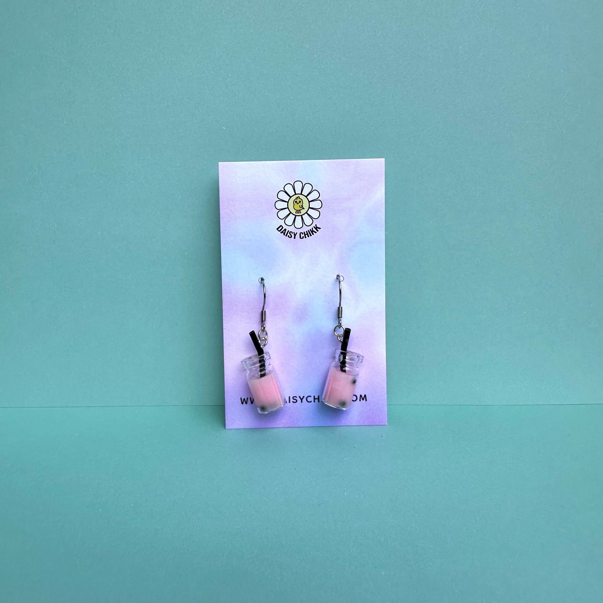 Pink boba tea earrings with silver hooks displayed on a pastel Daisy Chikk backing card – handmade kawaii bubble tea jewellery