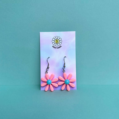 pink daisy flower earrings with white centre on silver hooks, displayed on pastel Daisy Chikk backing card – kawaii handmade statement jewellery