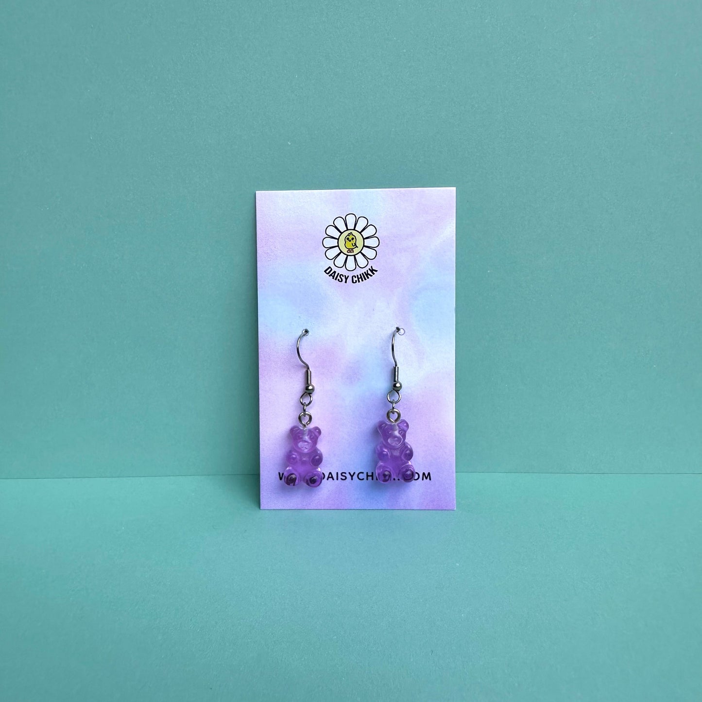 Purple gummy bear earrings on silver hooks displayed on a pastel Daisy Chikk backing card – handmade kawaii resin earrings
