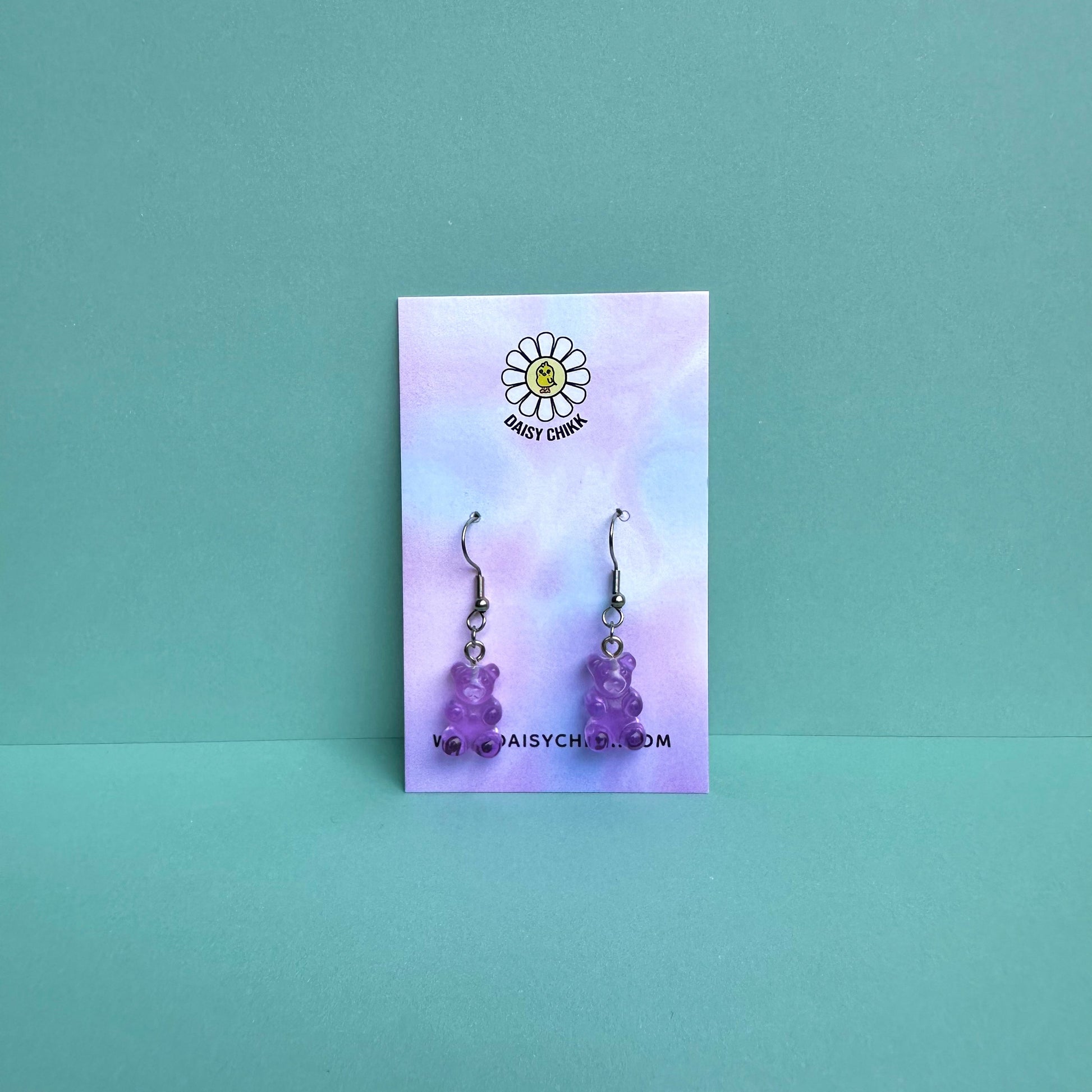 Purple gummy bear earrings on silver hooks displayed on a pastel Daisy Chikk backing card – handmade kawaii resin earrings
