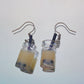 Close-up of handmade milk boba tea earrings with black straws and silver hooks – kawaii resin bubble tea jewellery