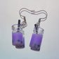 Close-up of handmade purple boba tea earrings with black straws and silver hooks – kawaii resin bubble tea jewellery